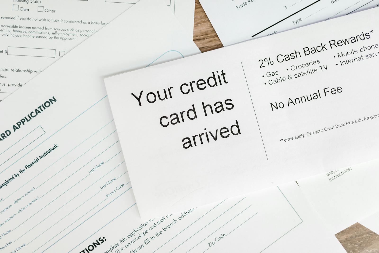 Close-up of a letter announcing the arrival of a credit card amidst financial documents.